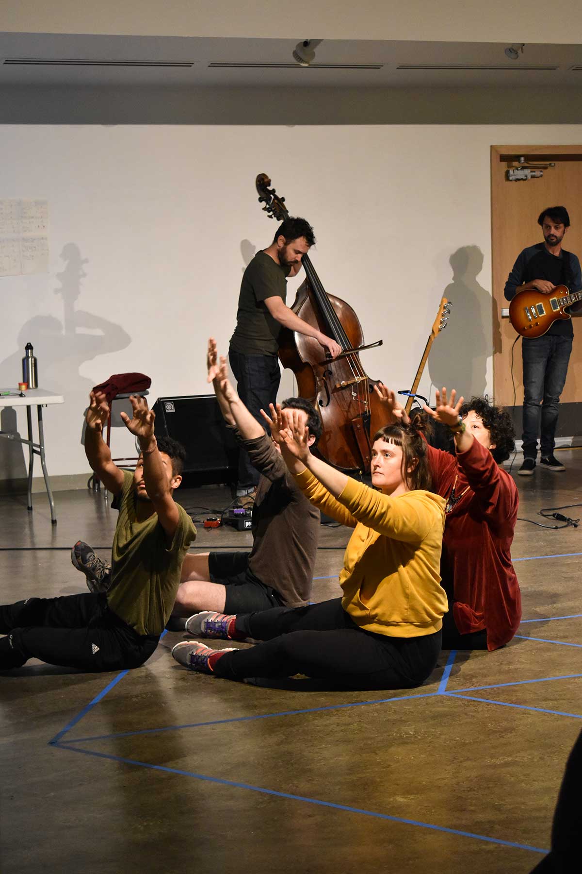 Performers dance and play musical instruments with lights and video projection at Vachon Gallery 