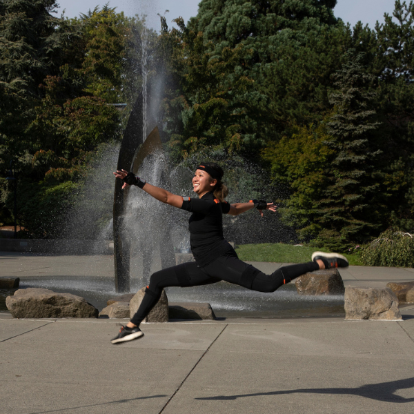 Dancer wearing a mask in front of a fountain