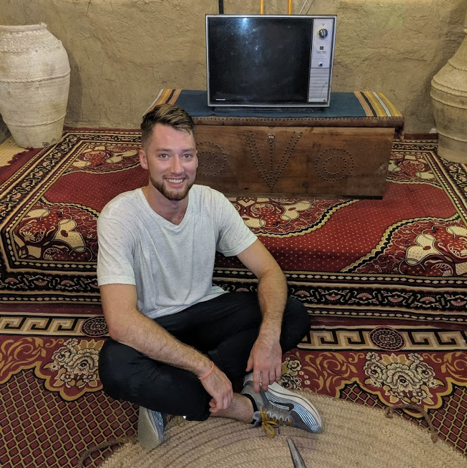 Sam sitting on the floor in front of a television