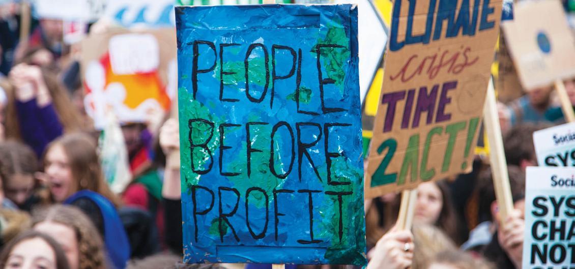 Protester holding up sign saying People Before Profit