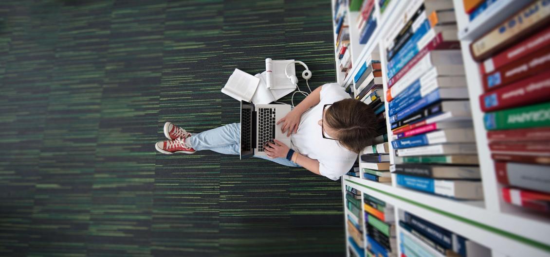 Student studying in library with laptop