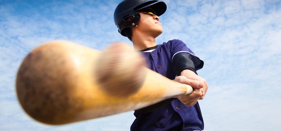 Baseball player hitting ball with bat