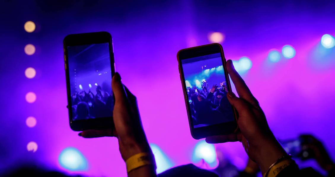 Photo of people recording a show with cell phones. 