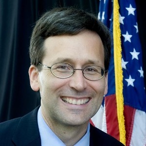 Bob Ferguson in front of flag.