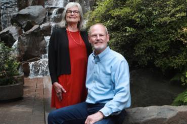 Tricia and Steve sitting in garden on campus