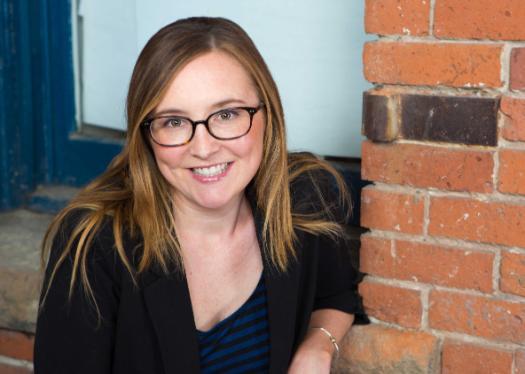 a profile photo of Carey Evenson standing next to a brick wall