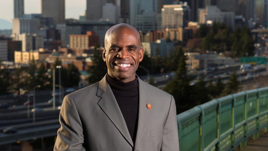 Alumnus Gordon McHenry standing on a bridge in front of downtown Seattle