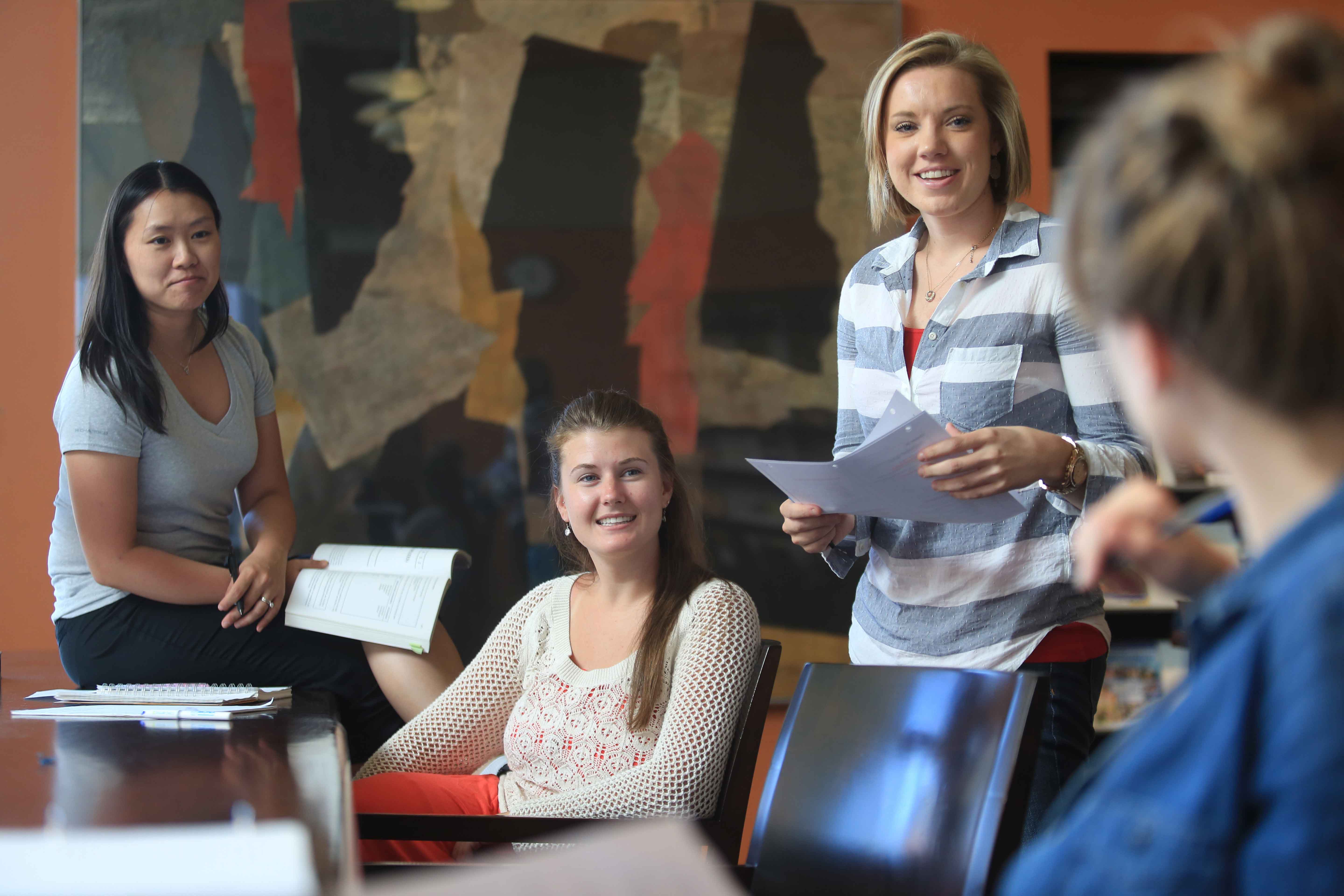 Groups of women talking and holding paper