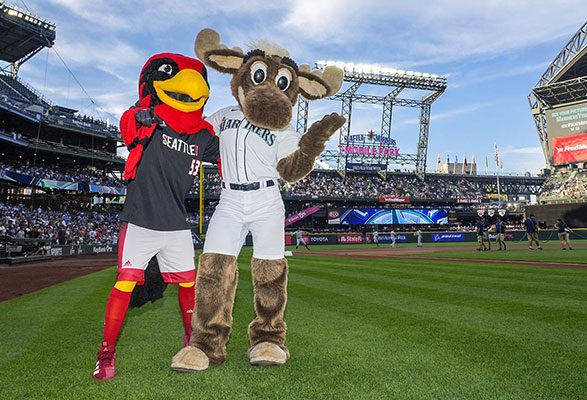 SU and Mariners mascots posing on the baseball diamond