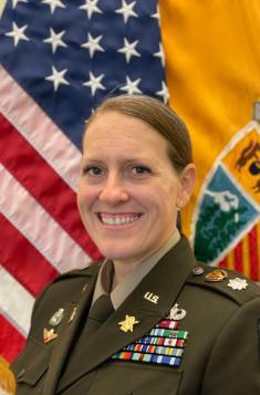 woman in uniform before flags