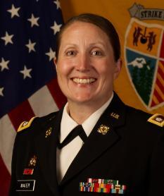 Woman in uniform in front of US flag