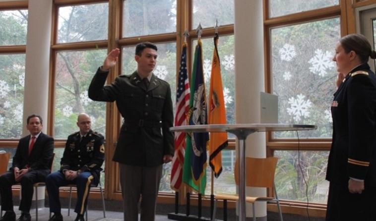 Man in uniform before flags with salute