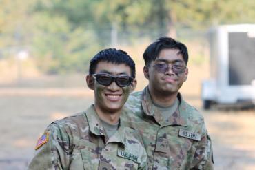 two cadets in camo makeup and greens outside day