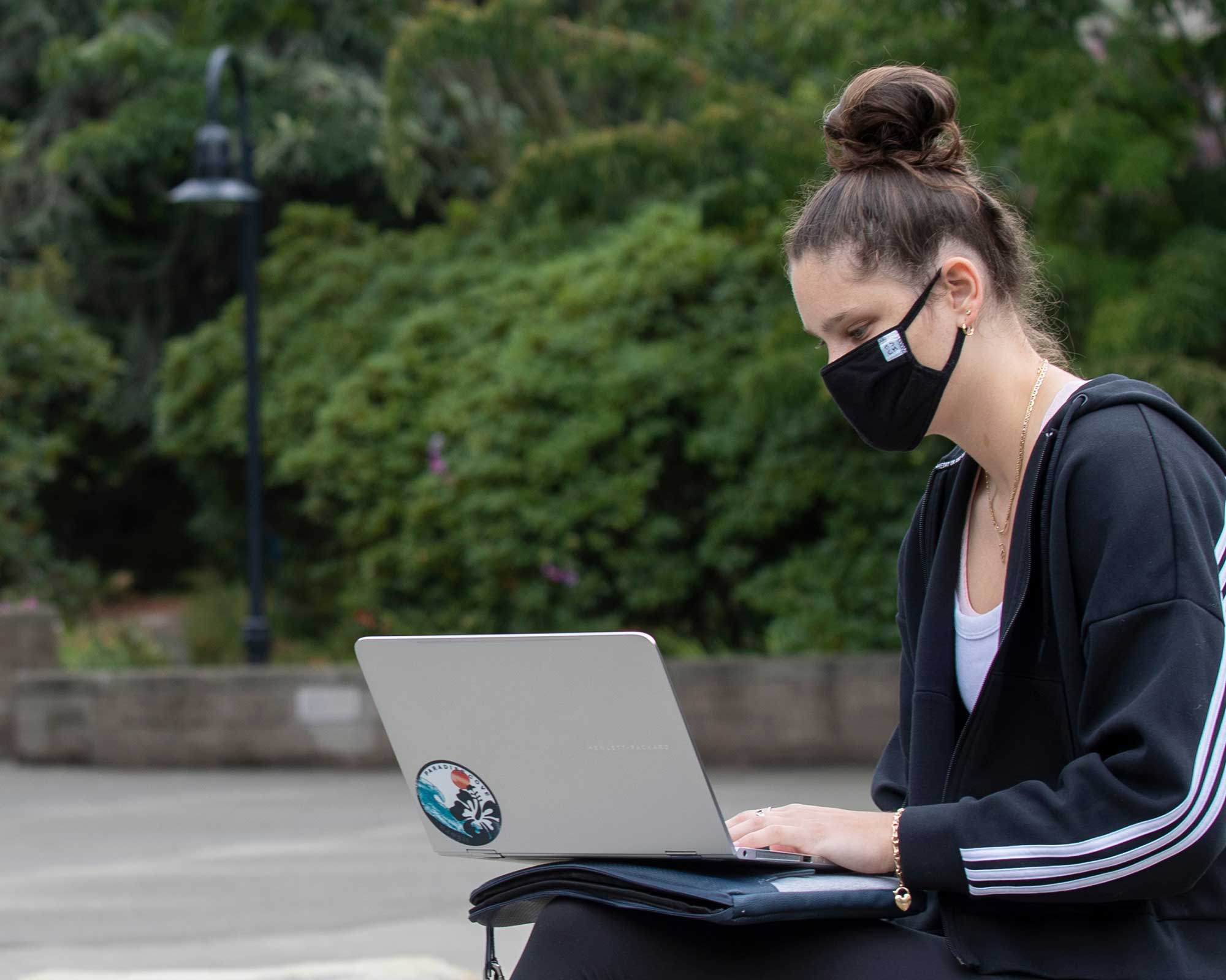 Student working on laptop wearing a mask