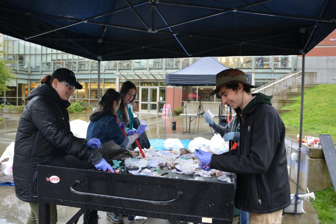 Students sort through trash to prevent recycling and compost from going to the landfill.