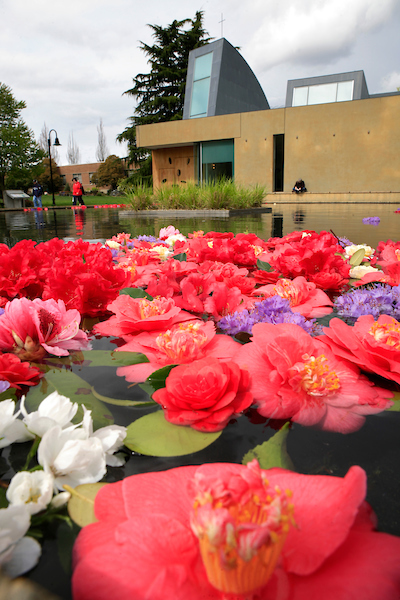 Bright flowers next to the reflection pool with Chapel of St. Ignatius in the background