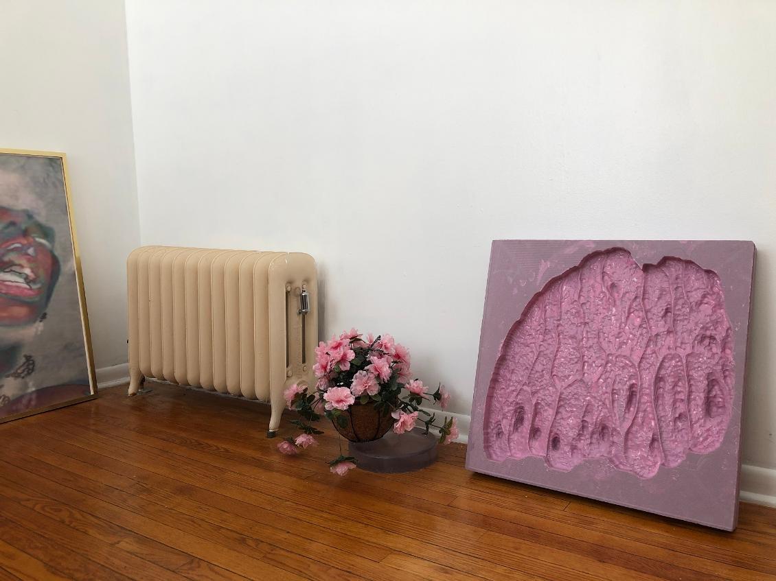 Image of artwork with two paintings, a radiator and flowers