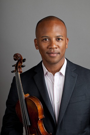 Dr, Quinton Morris holding a violin