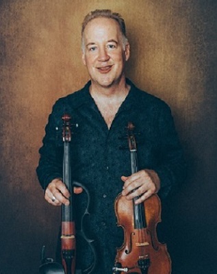 Middle aged man holding two violins