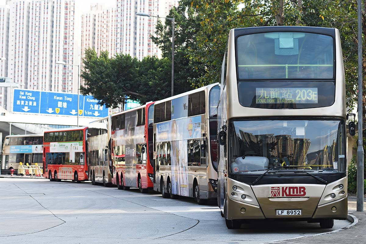 photograph of a series of double decker bus in a line on a street