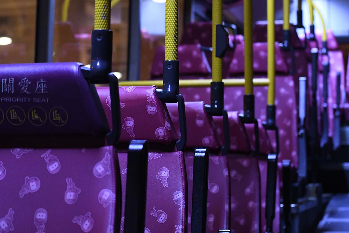 photograph of the interior of an empty bus at night with rows of seats