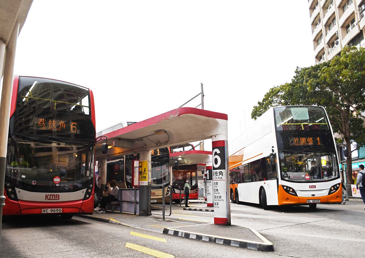 photograph of two busses at a y shaped intersection