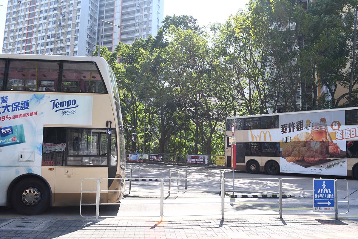 photograph of the front side of a bus heading in one direction and a second bus further away heading in the other direction