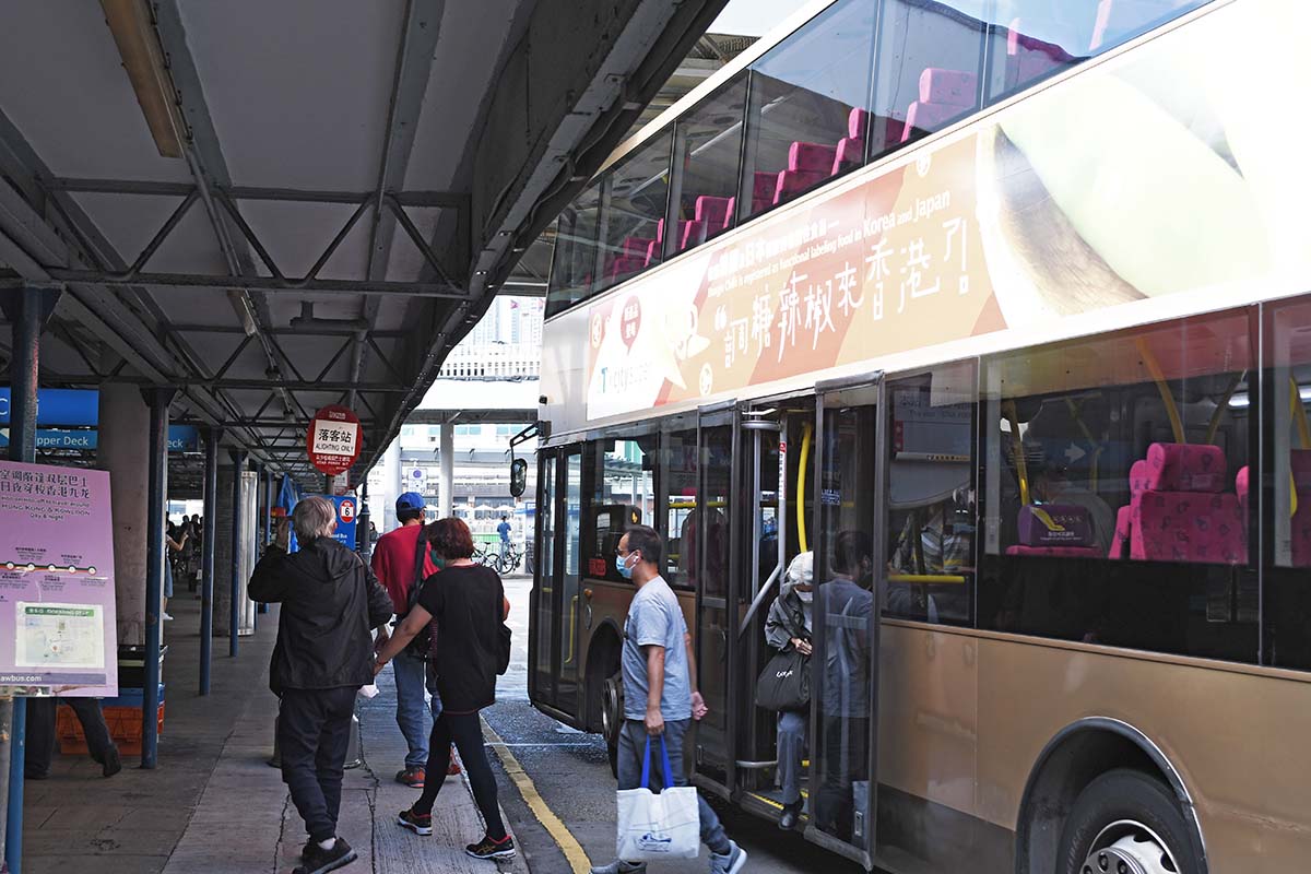 people gettin off a bus at a building