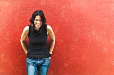 Woman leaning against red painted wall