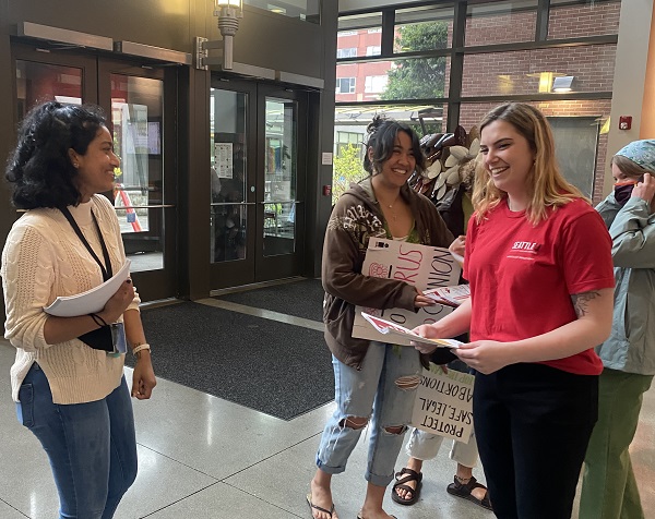 Students hand out flyers for club