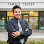 Man standing in front of Campus Center sign