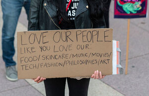 Person holding a sign that says 