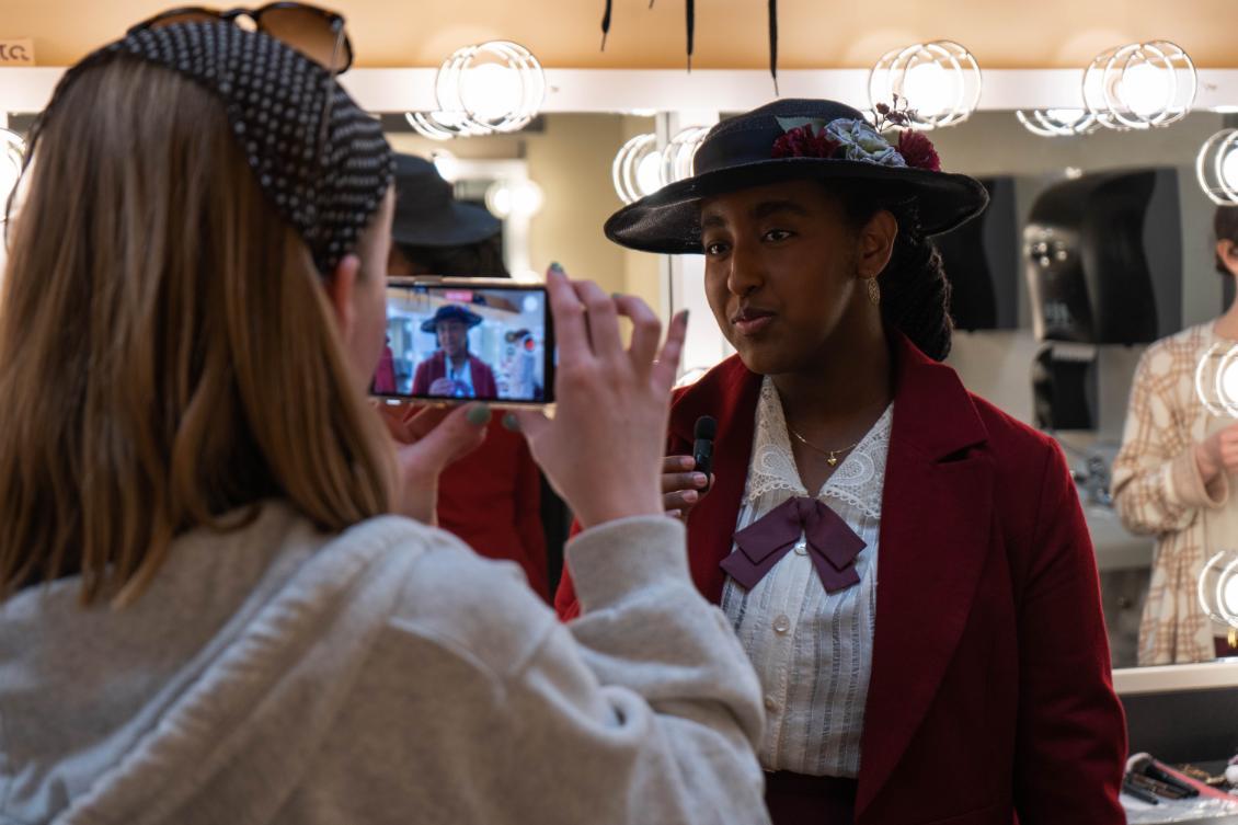 Student in foreground taking a photo of another student in costume