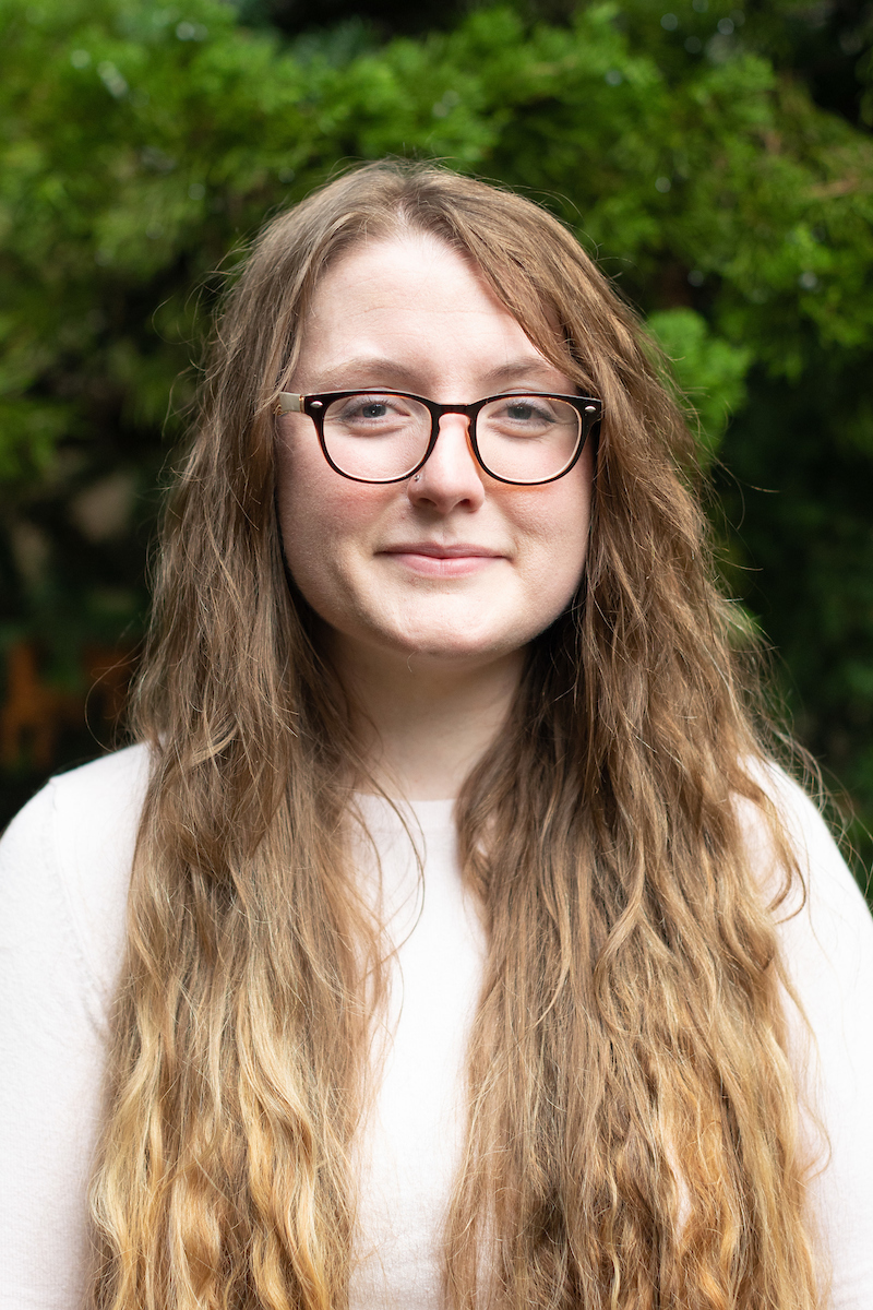 Valerie with long curly hair, glasses