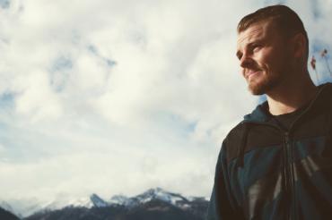 Alex standing against sky backdrop