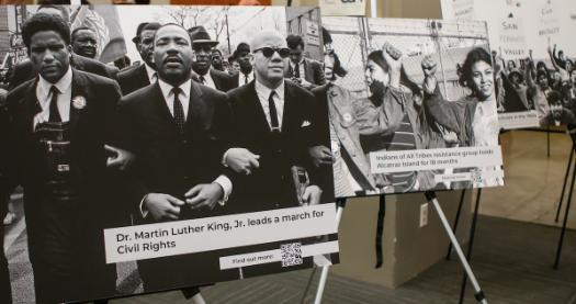 People looking at posters featuring civic rights leaders.