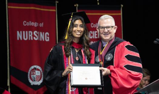 A photo on stage with the student speaker and Shane Martin