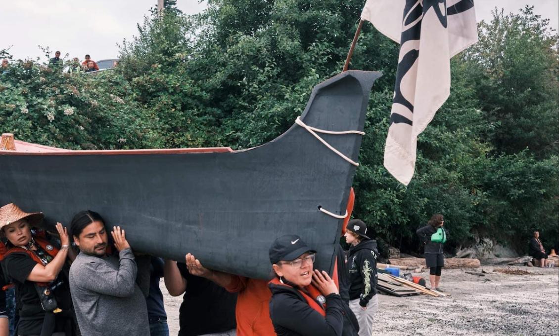 Branddi carries canoe at Alki Beach.