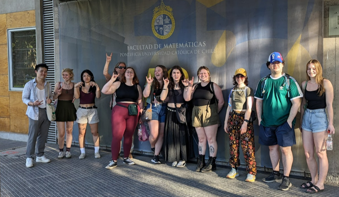 Students stand in front of a mural while on spring break in Chile.