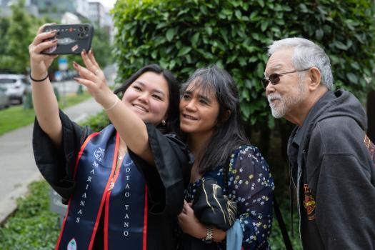 Student with parents on graduation day.