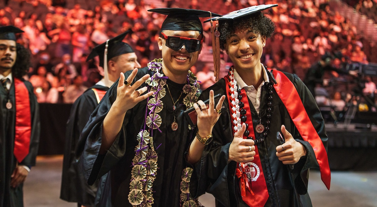 Two guys graduates celebrating during commencement