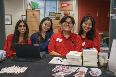 smiling staff greet new and returning students at move in day