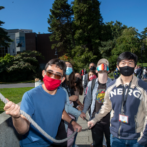 Students hold on to a rope to ring the chapel bell on campus