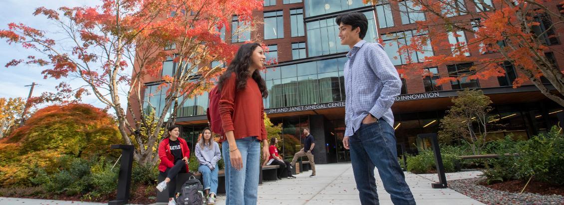 Two students talking in front of Sinegal