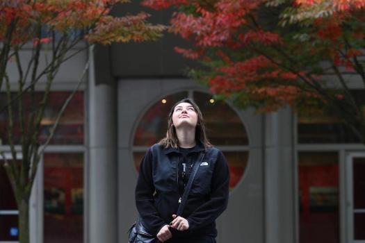 Student on campus looking up to sky