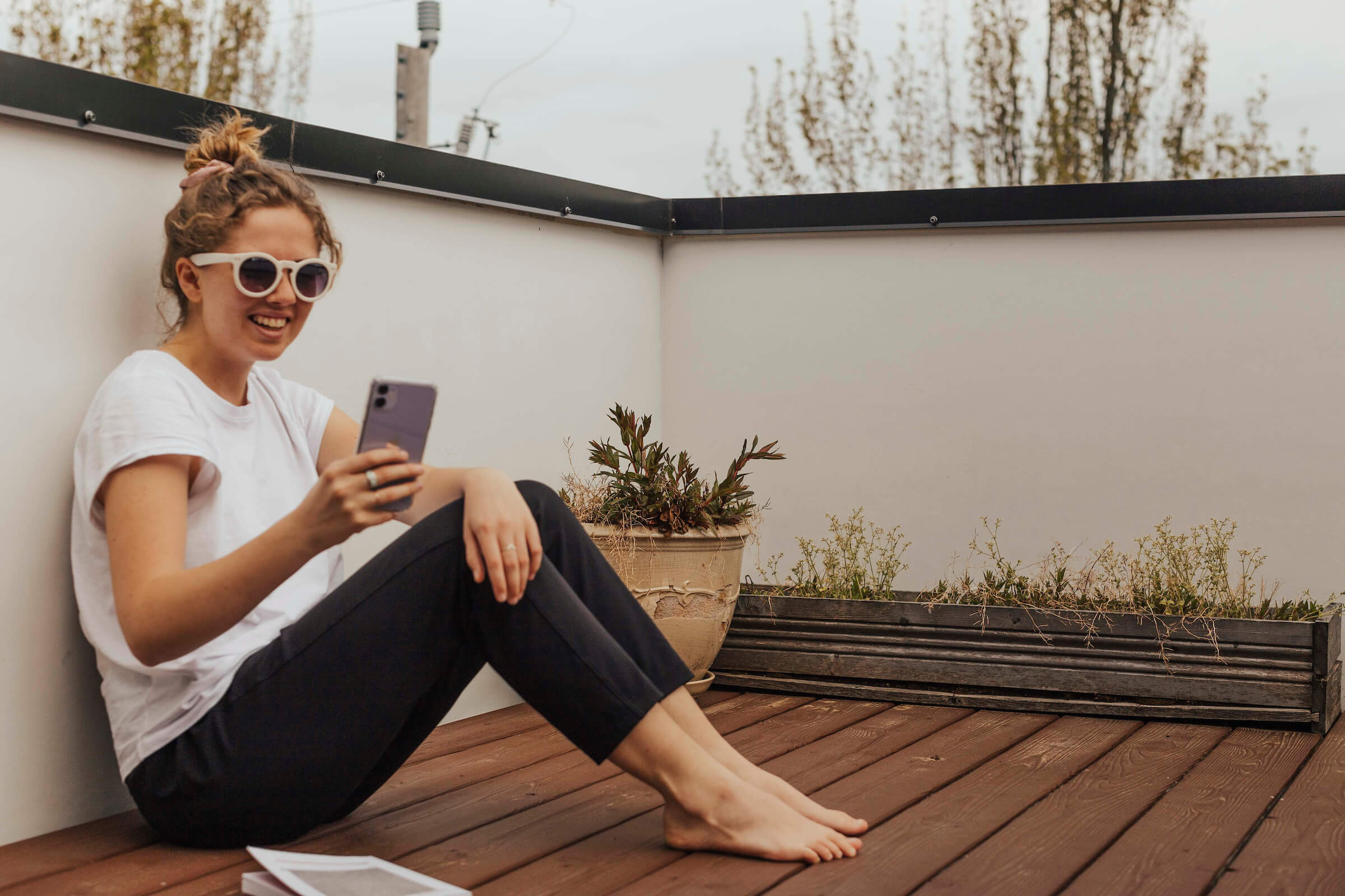 Hallie video chatting on her phone while sitting outdoors