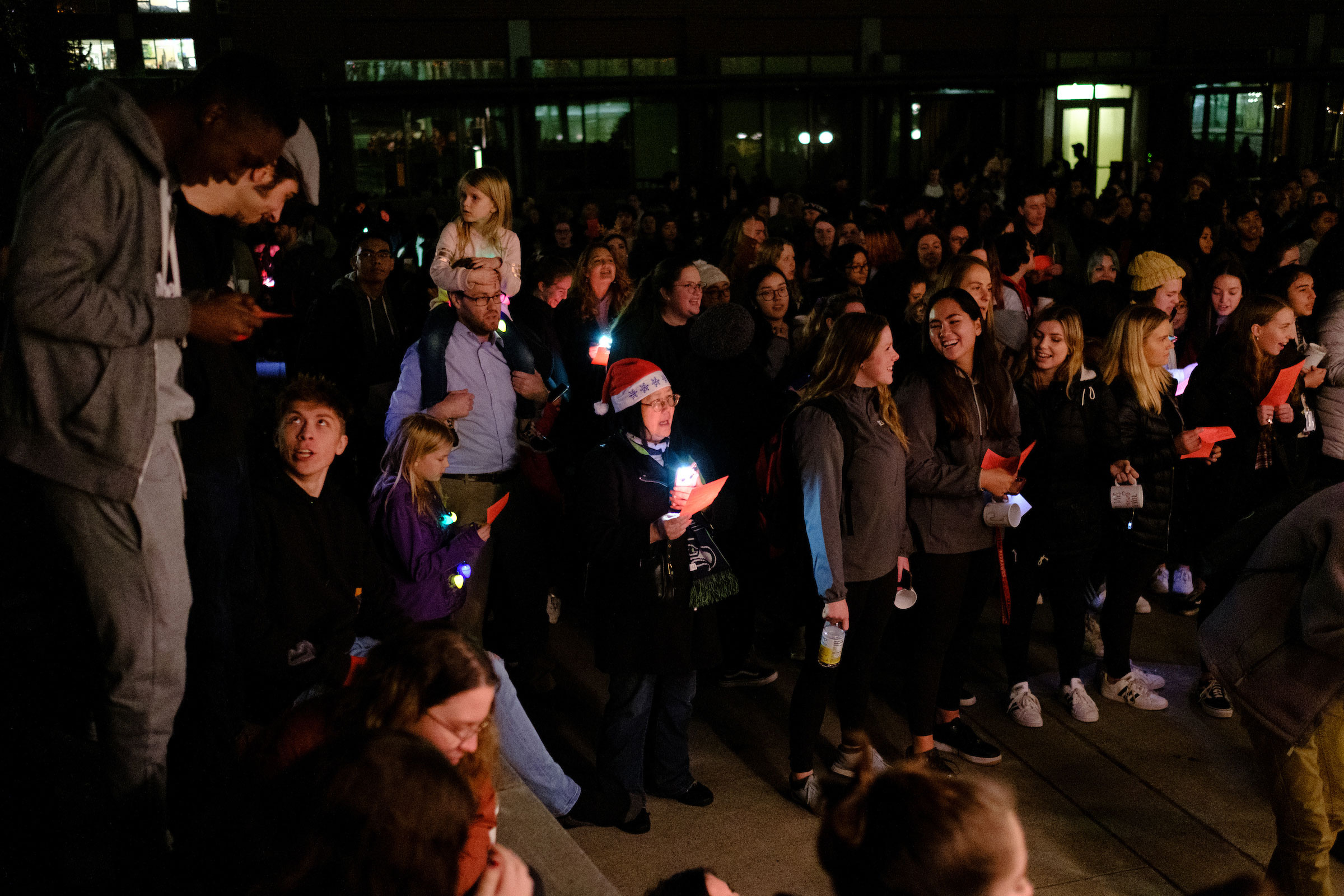 a crowd of campus community members gather together singing