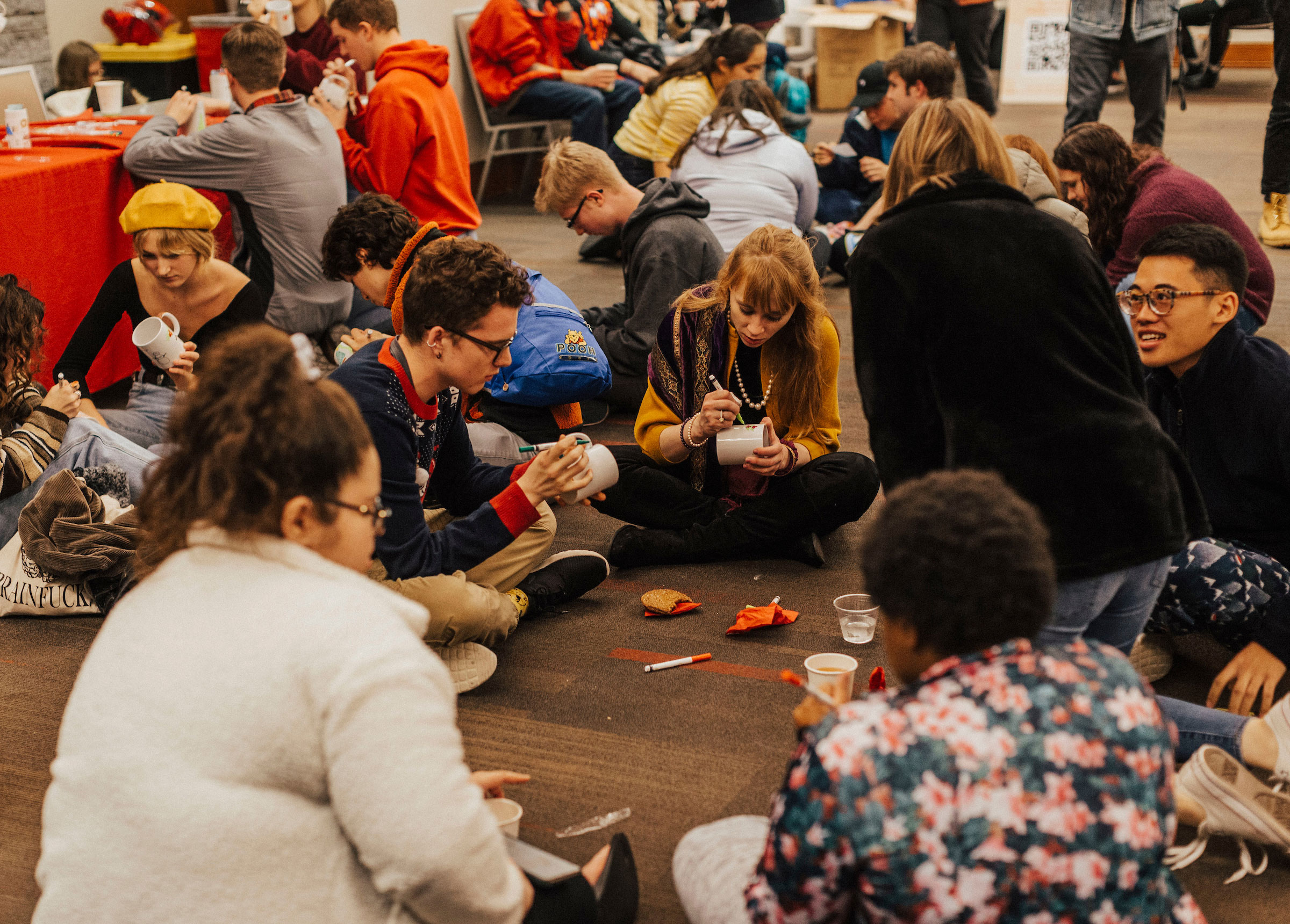 students sit together in circles decorating mugs for Christmas