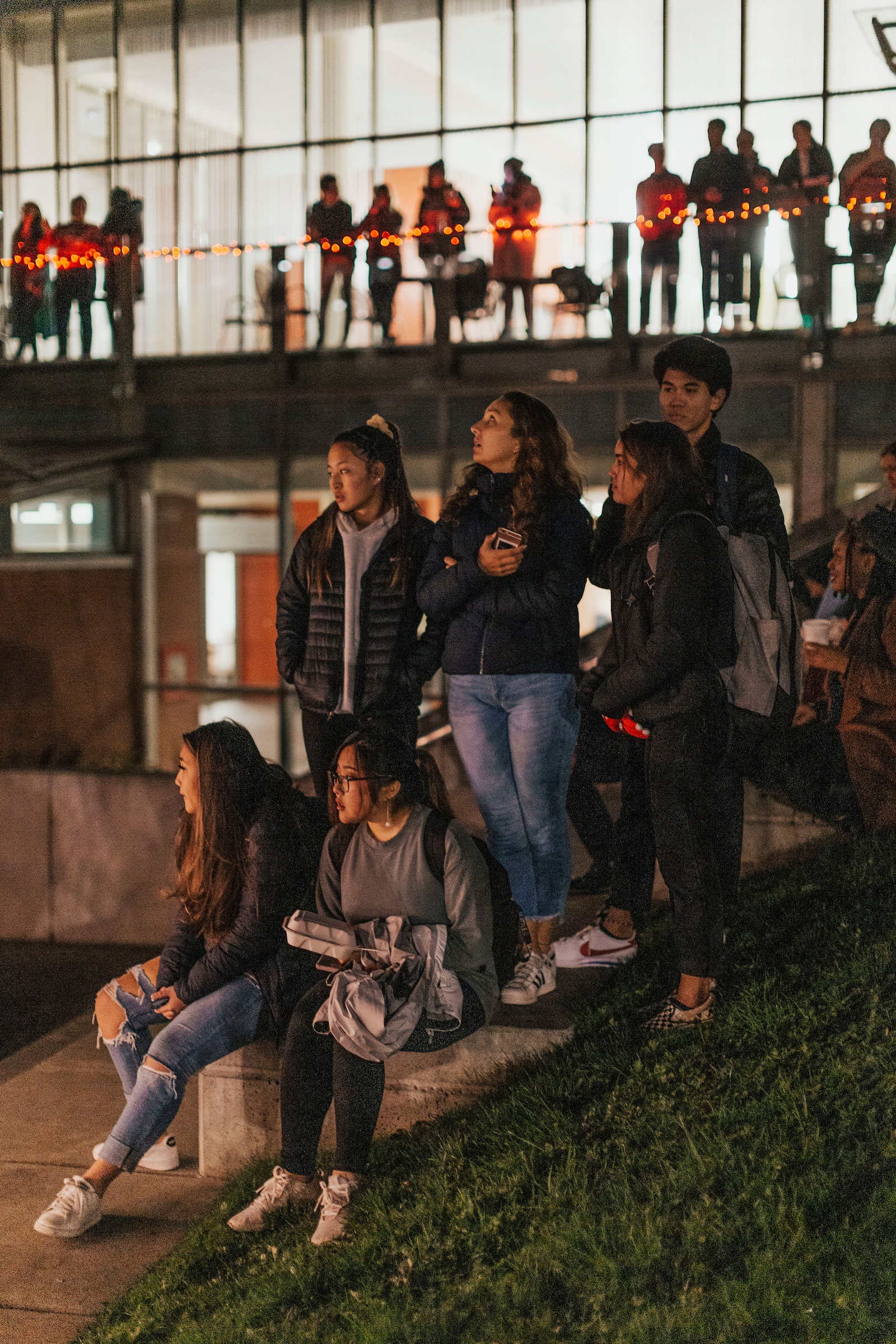 students watch the Christmas Tree Lighting from the library steps and balcony 