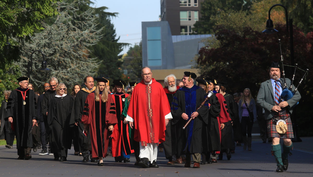 Father Steve leads a group of faculty, staff, community members down the lower mall near the Chapel.